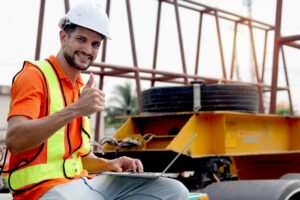 Construction worker with computer using AI solutions to boost safety.