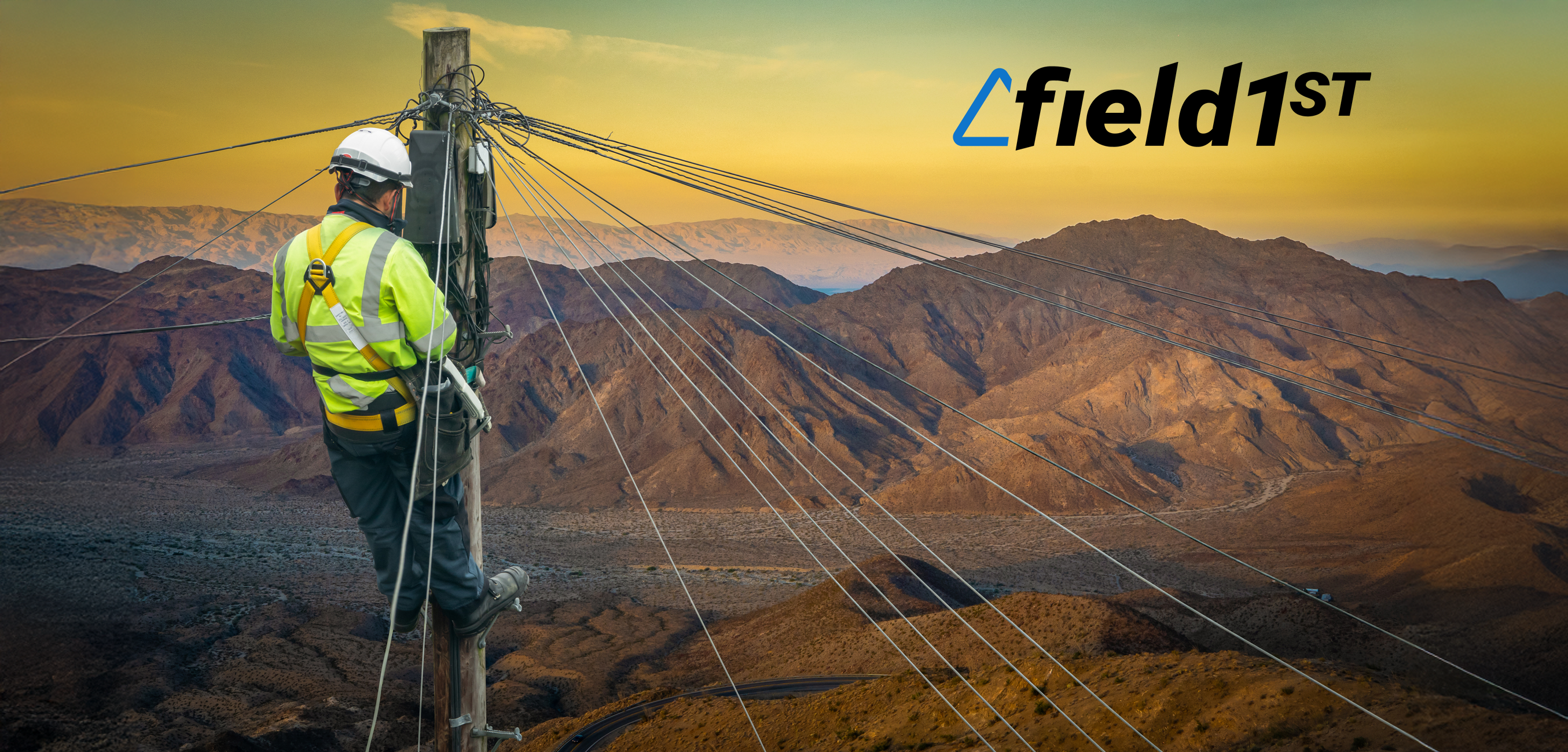 A utility worker high up on a telephone pole in the desert at sun set happy that his company has a safety plan for utility workers.