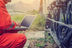 Electrician using a laptop to help with hazard reporting