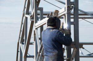 A man welding on a phone tower.