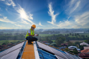 Man on rooftop with solar panels using job safety evaluation tools.