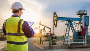 A man on an oil refinery site conducting OSHA compliance inspection.